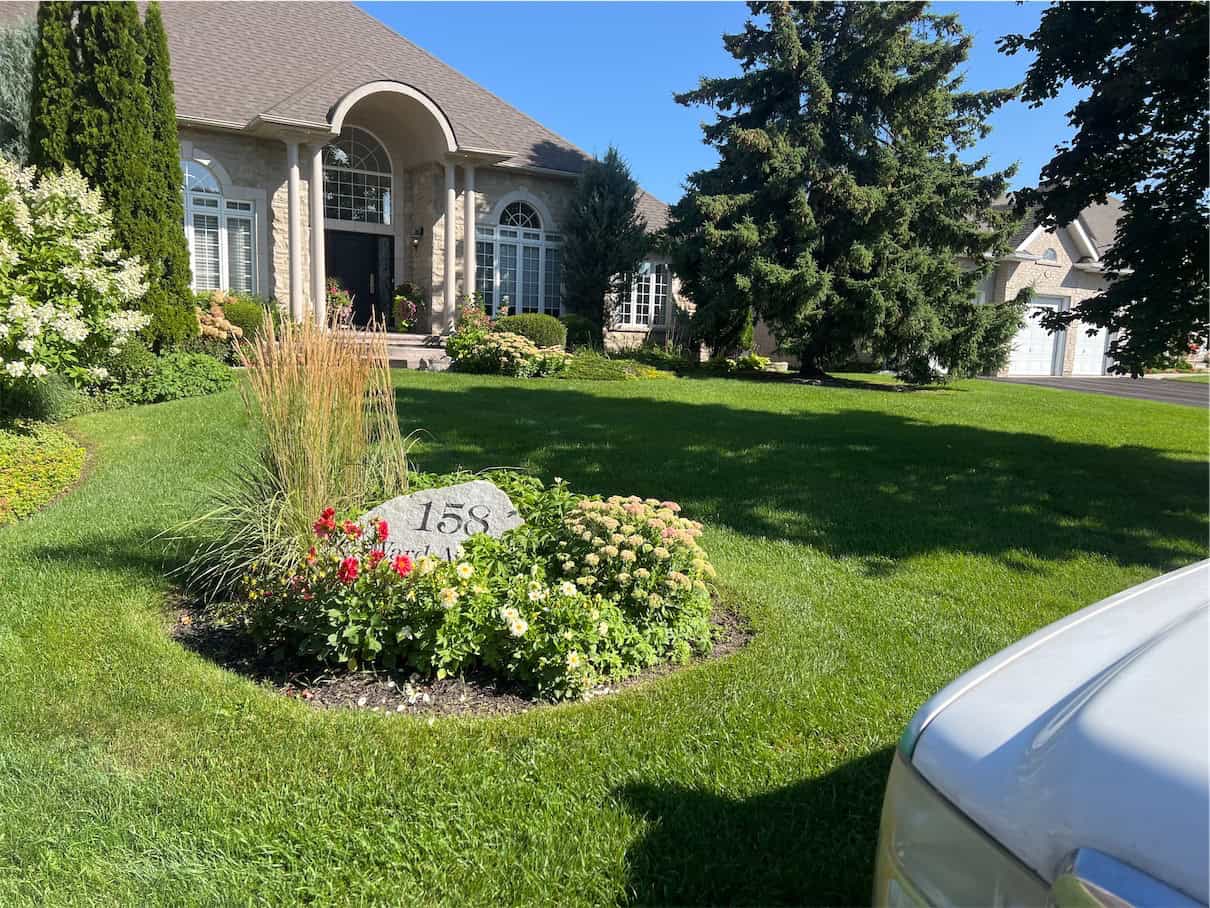 Manicured front lawn and garden bed in Pickering maintained by LawnSavers lawn care