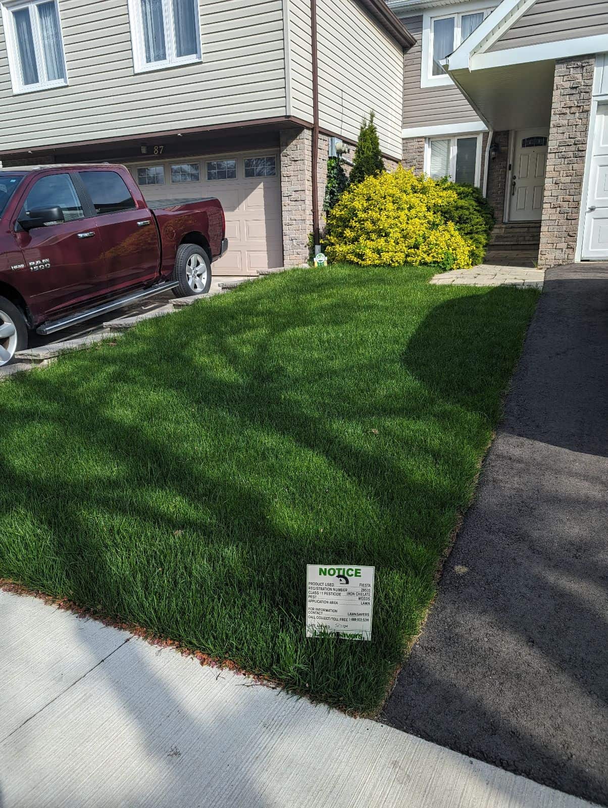 Thick green front lawn treated by LawnSavers lawn care service in the GTA, with LawnSavers lawn sign